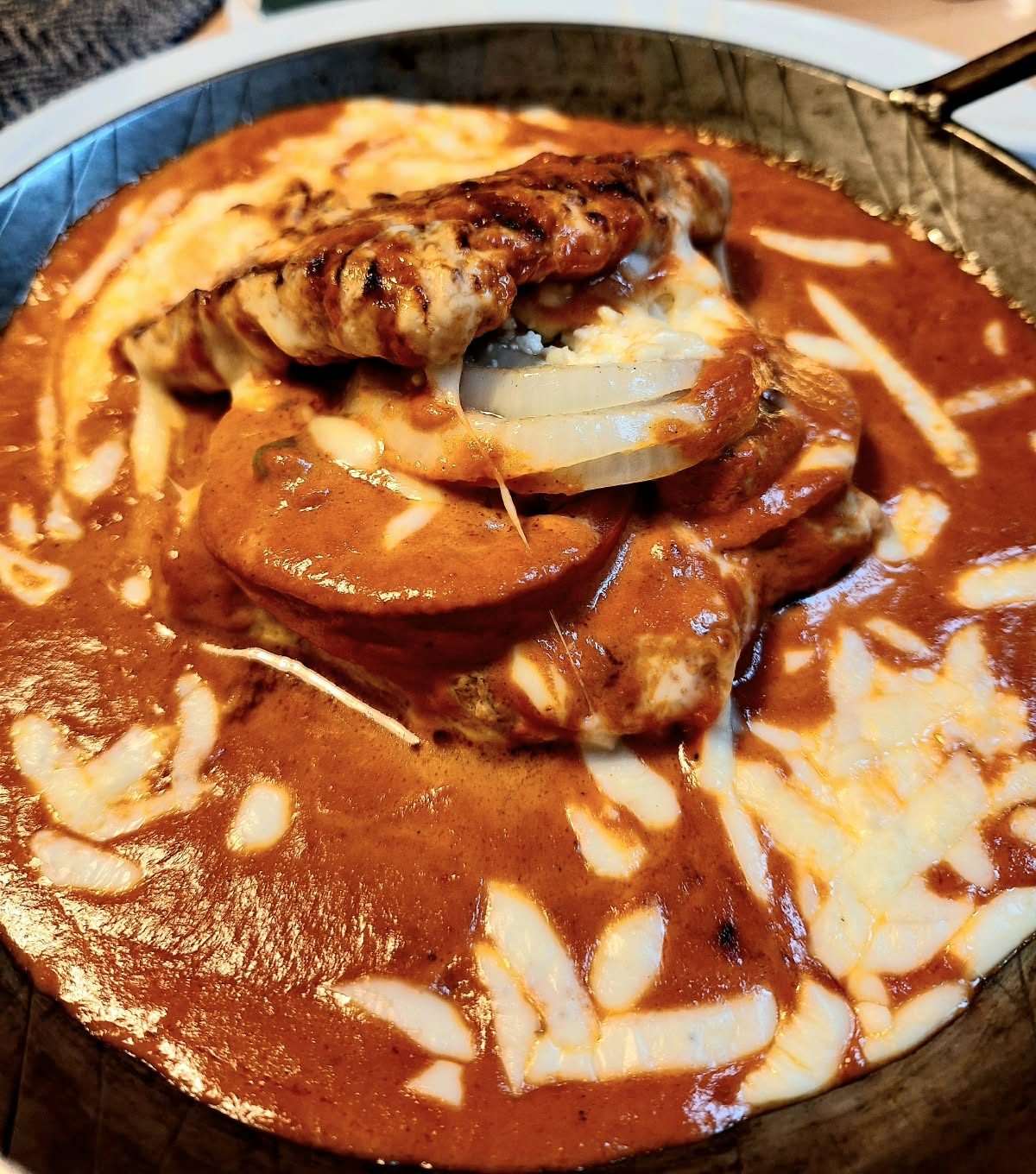 Fleisch mit Metaxa-Sauce und Käse überbacken, in der Pfanne